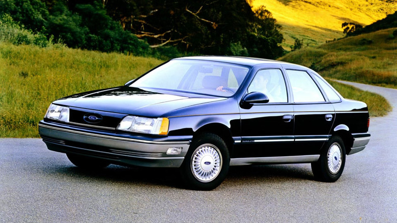 A 1987 Ford Taurus sedately driving through the countryside