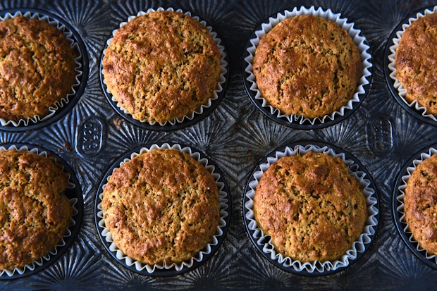 bran muffin batter next to muffin tin being filled