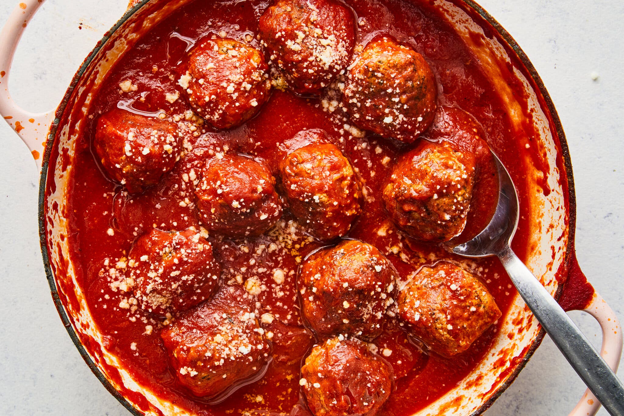 An overhead image of a Dutch oven filled with sauced meatballs.