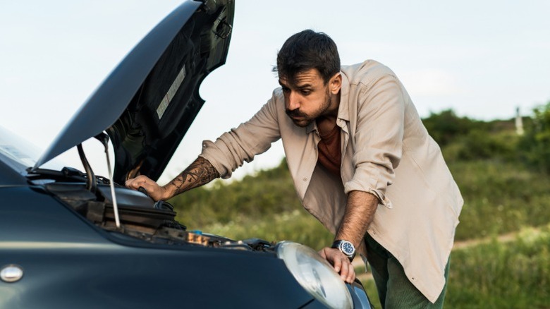 a frustrated person listening to their engine make strange sounds