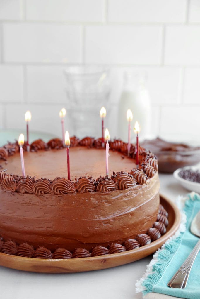 a chocolate birthday cake with candles on a marble countertop